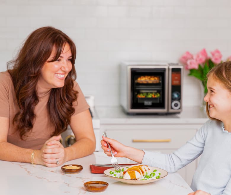Parent and child sharing a Suvie meal at the kitchen island
